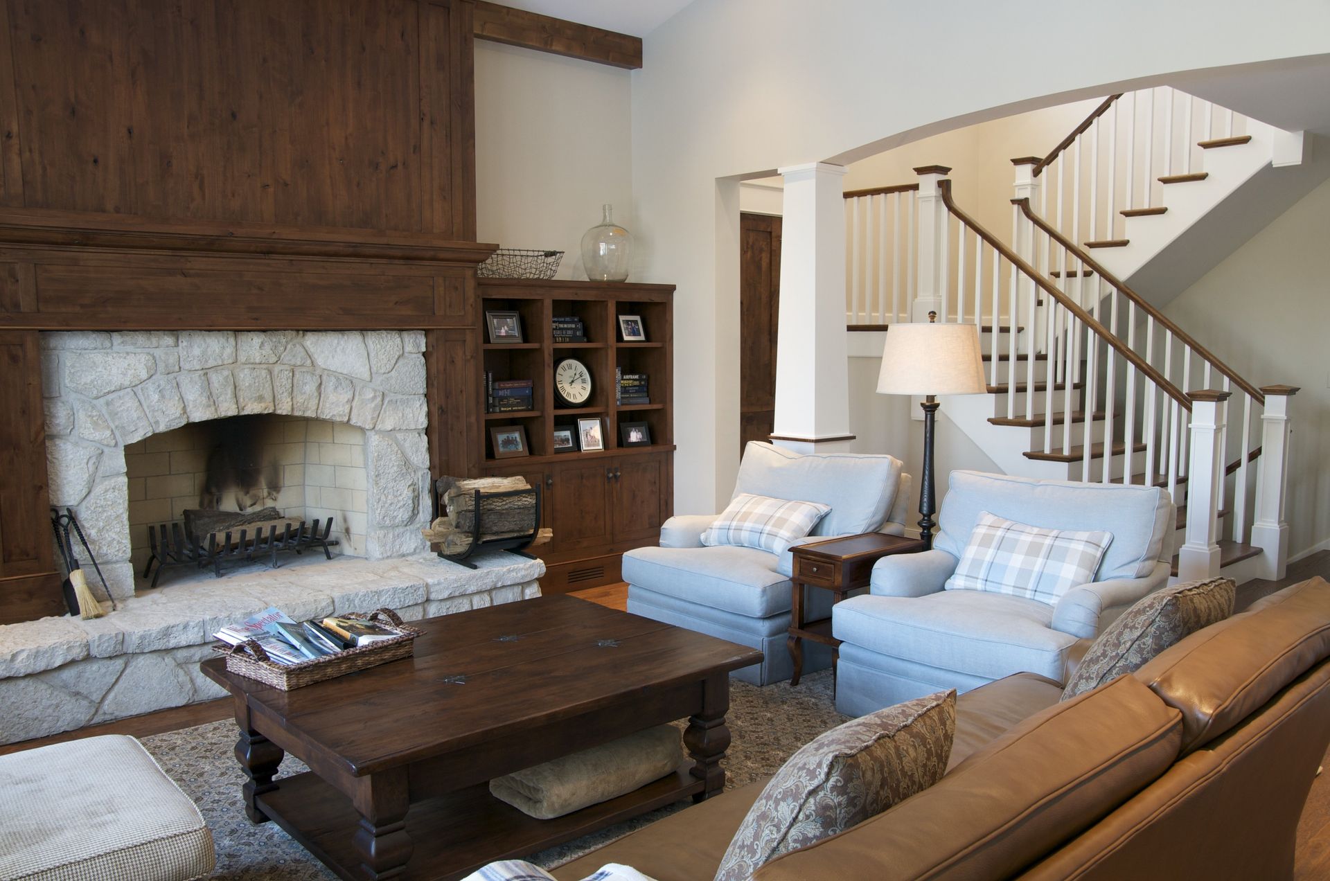 A living room with a fireplace and stairs in the background