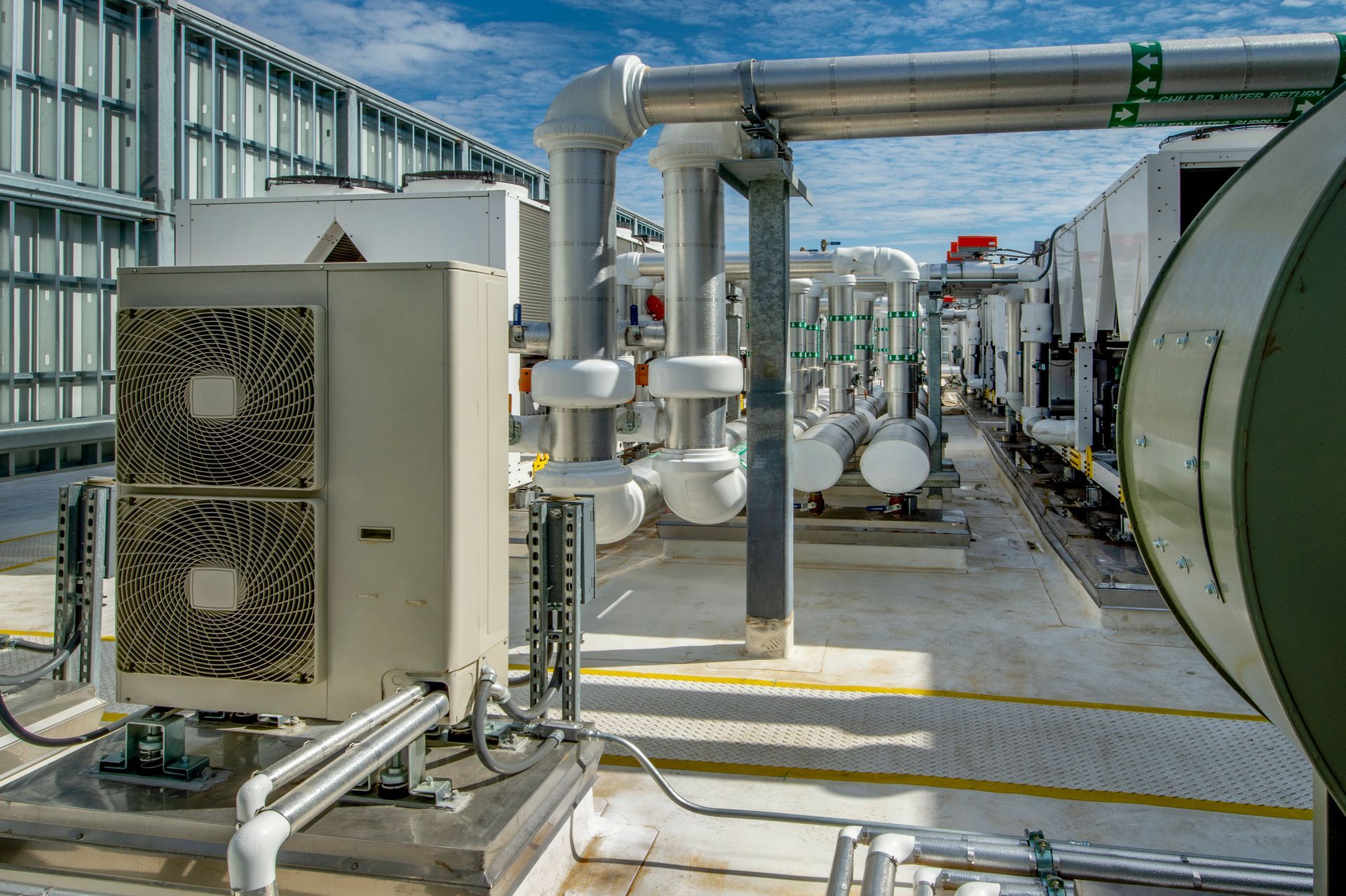 Apparecchiature HVAC sul tetto: unità di condizionamento dell'aria, tubazioni, prese d'aria, in una giornata limpida.