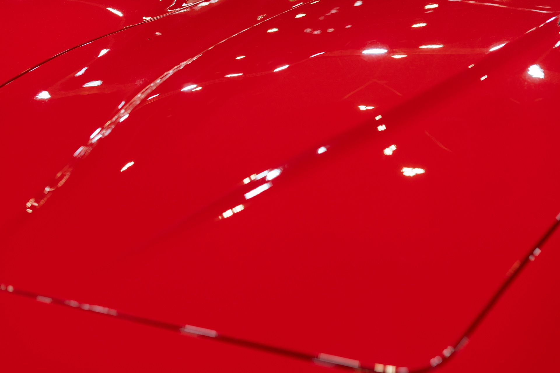 A close up of the hood of a red car