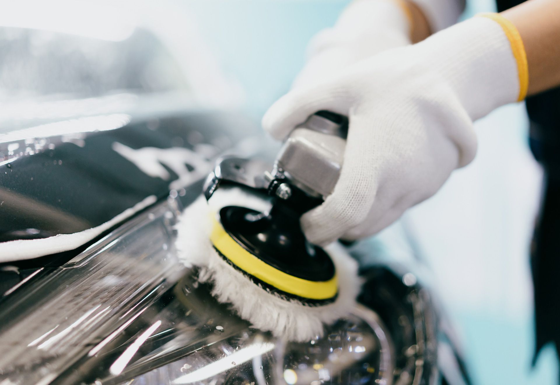 A person is polishing a car with a brush.