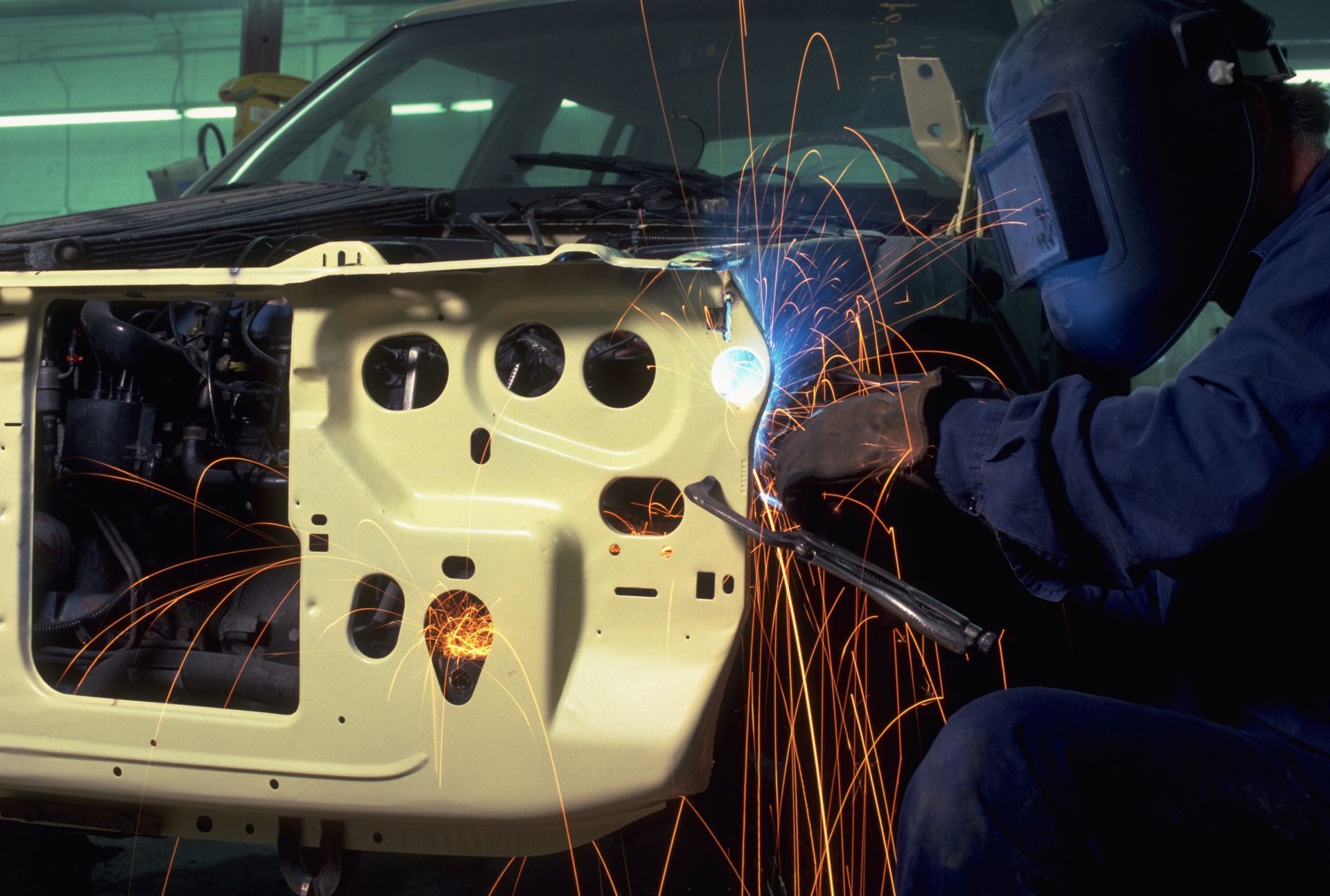 A person is fixing a car with a pair of scissors.