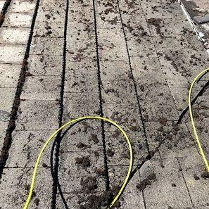 Dirty rooftop with debris, yellow cords present.