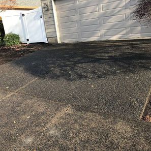 Driveway with a garage and white fence.