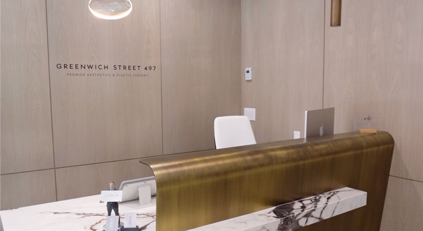 Reception desk with brass and marble accents, in a modern building. 