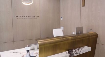 Reception desk with brass and marble accents, in a modern building.