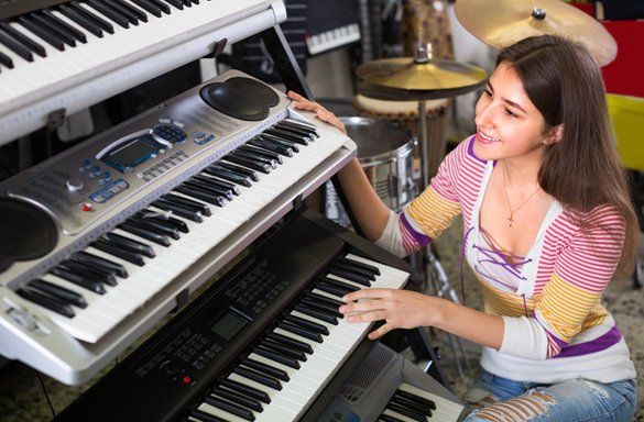 Woman Looking To A Keyboard Piano — Carmel, IN — Carmel Music Academy