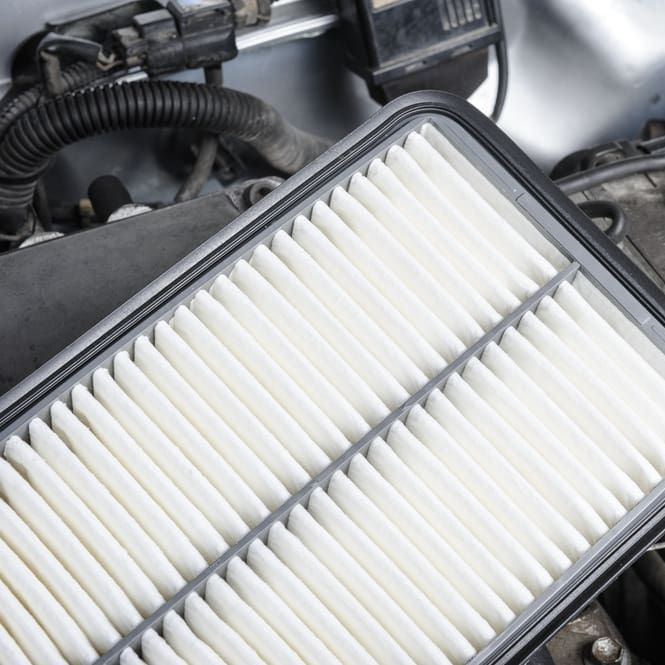 New, White Rectangular Air Filter, Held Near an Open Car Engine — Alice Springs Auto Parts in Ciccone, NT