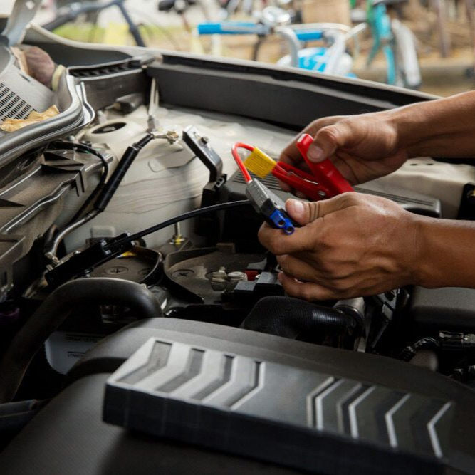 Hands Holding Jumper Cables, Connecting Them to a Car Battery — Alice Springs Auto Parts in Ciccone, NT