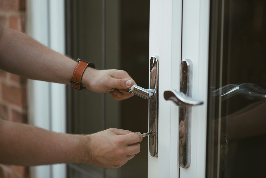 Man unlocking front door with key
