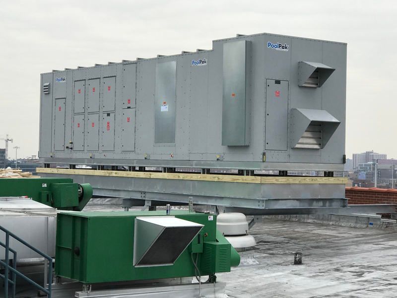 Large rooftop HVAC unit on a building; gray metal with air vents.