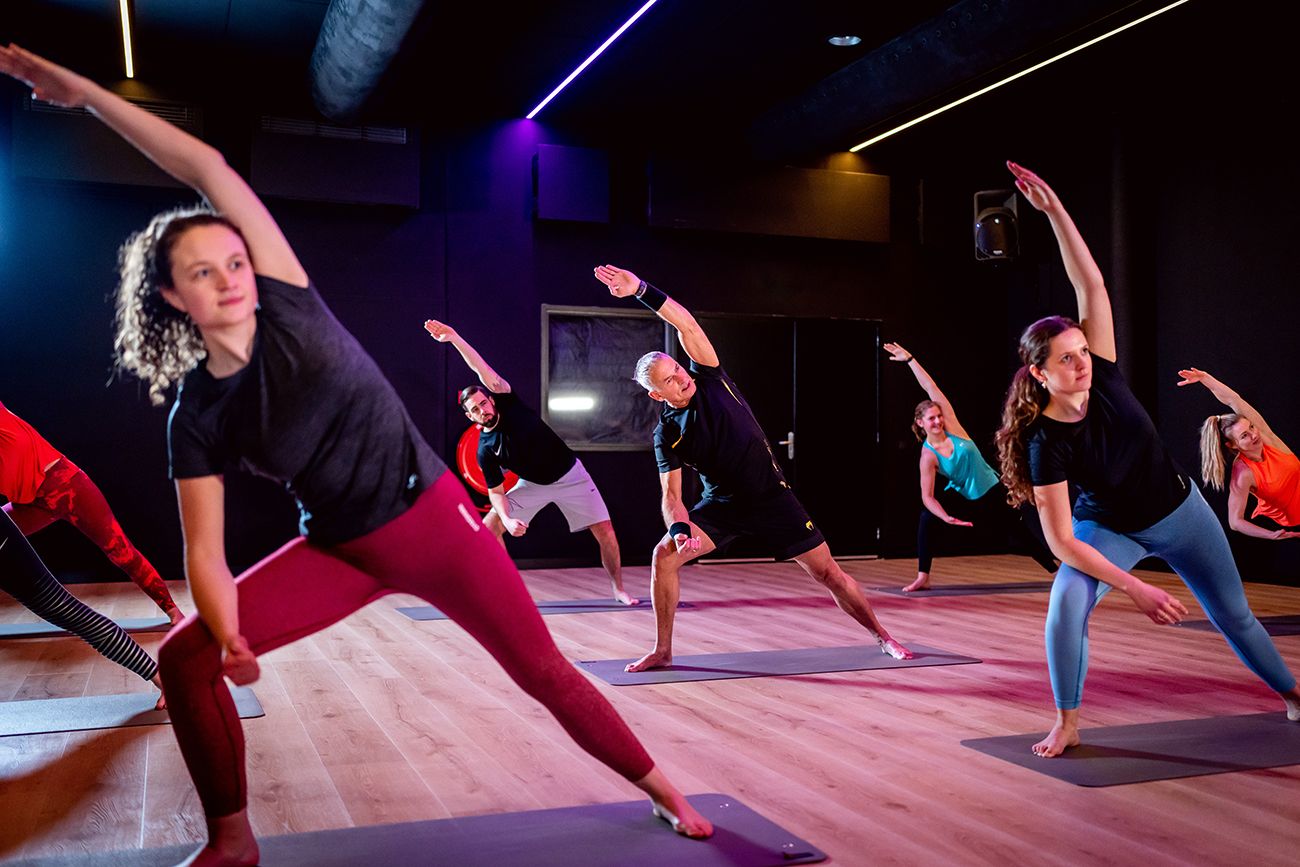 Een groep mensen doet yoga in een sportschool.