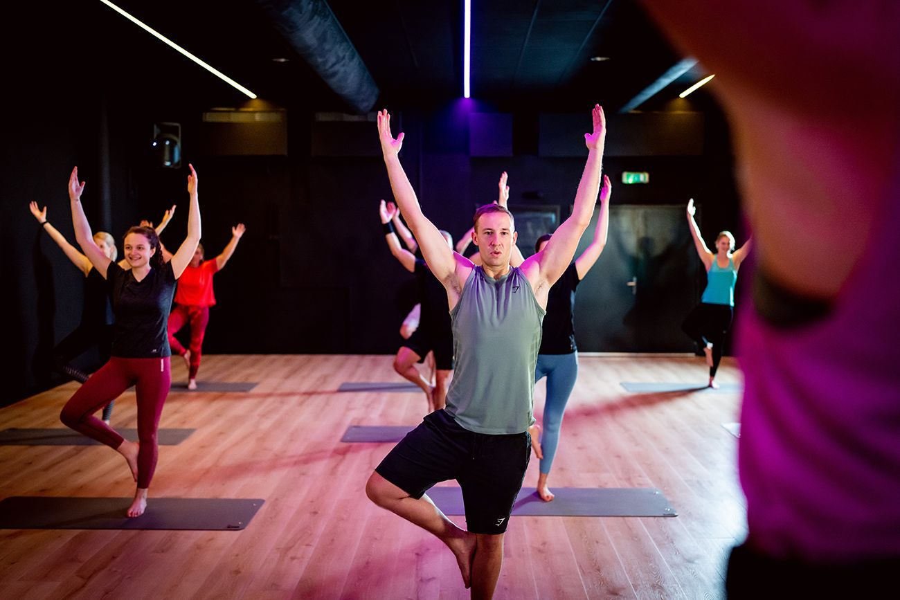 Een groep mensen doet yoga in een sportschool.