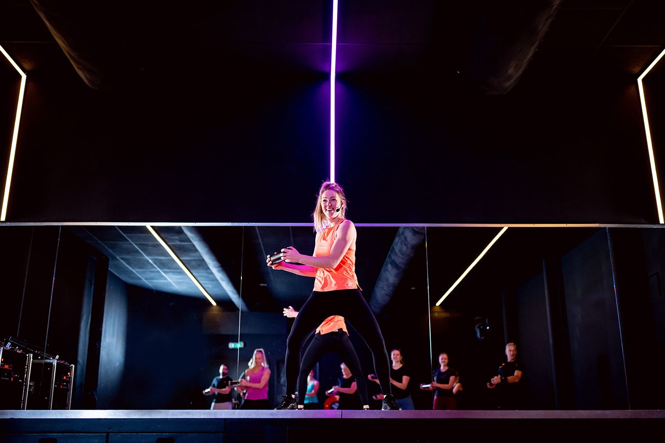 Een vrouw danst voor een spiegel in een dansstudio.