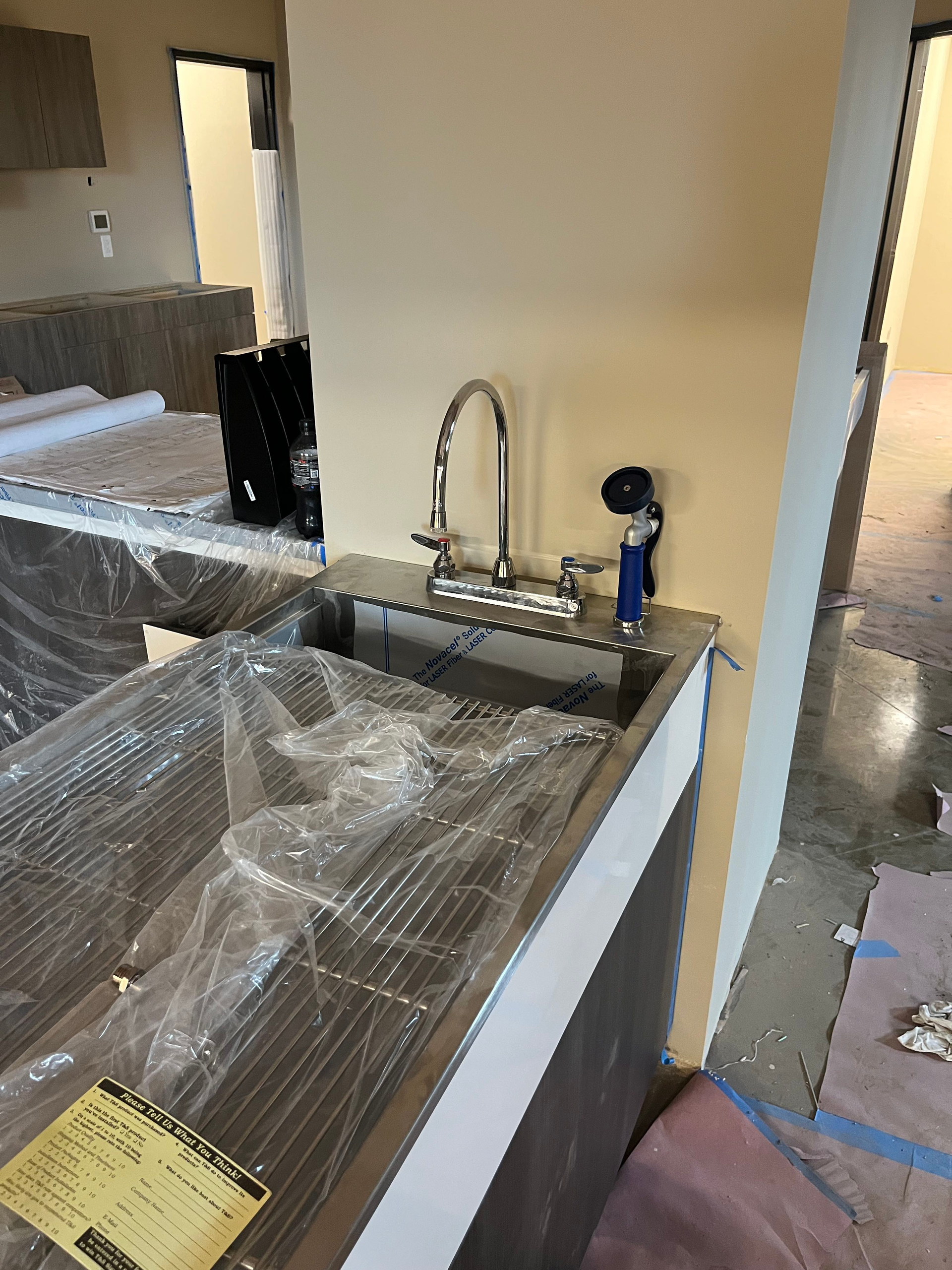 Stainless steel sink with a faucet, in a construction area.