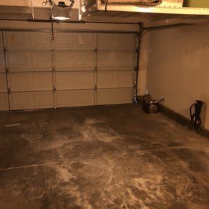 Empty garage with a closed overhead door. Concrete floor.