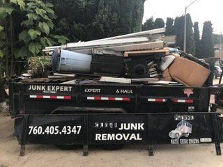 A dumpster overflowing with junk labeled 