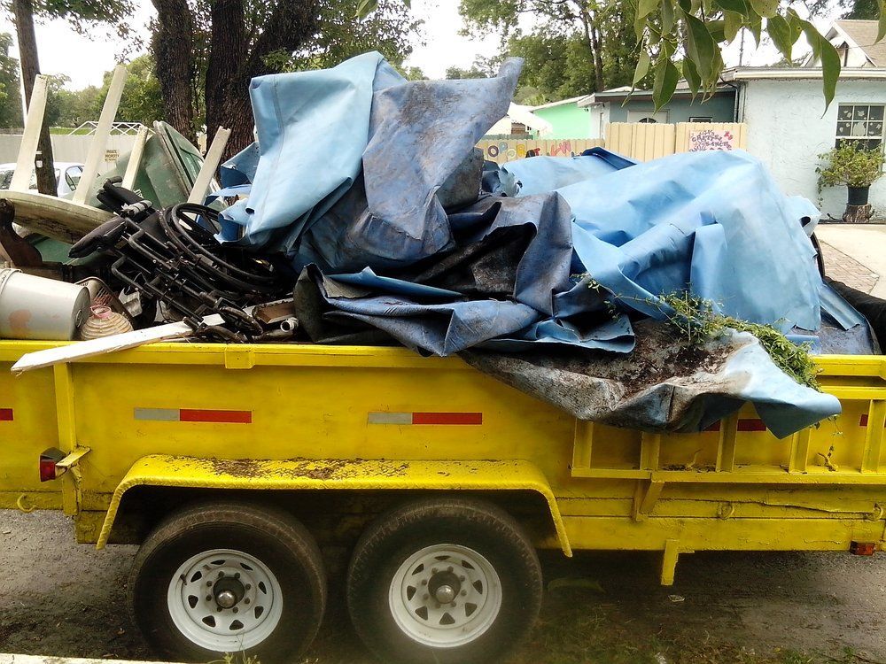 A yellow trailer with a blue tarp on top of it