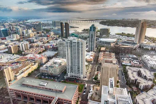 Aerial view of San Diego downtown cityscape with the bay and bridge in the background.