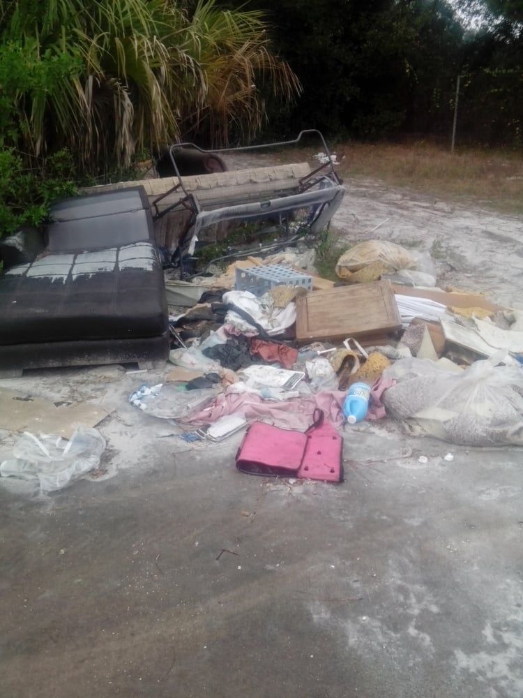 A pile of trash is sitting on the side of a road.