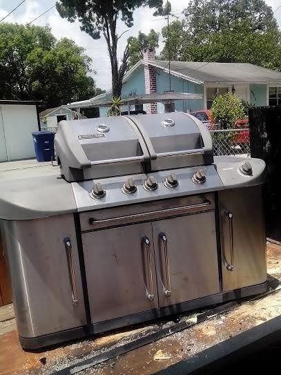 A stainless steel grill is sitting on top of a wooden table.