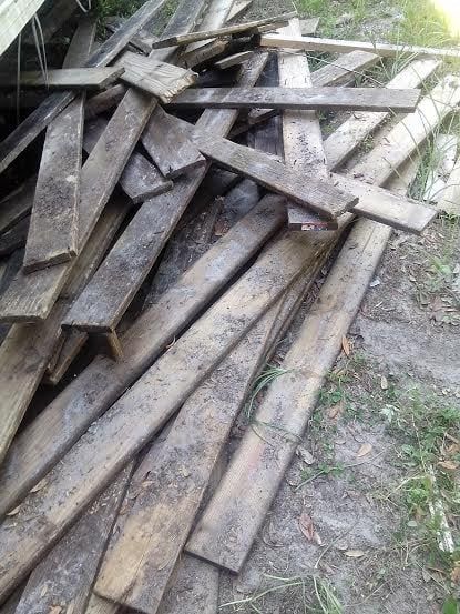 A pile of wood is laying on the ground.