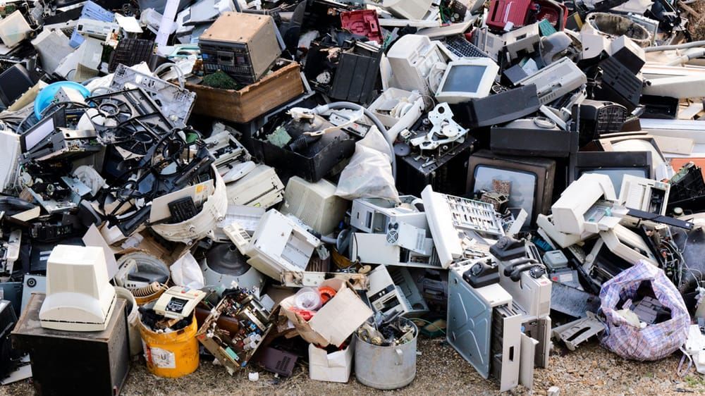 A pile of old electronic waste is sitting on the ground.