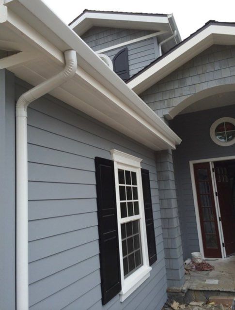 two story shingle roof with white gutters