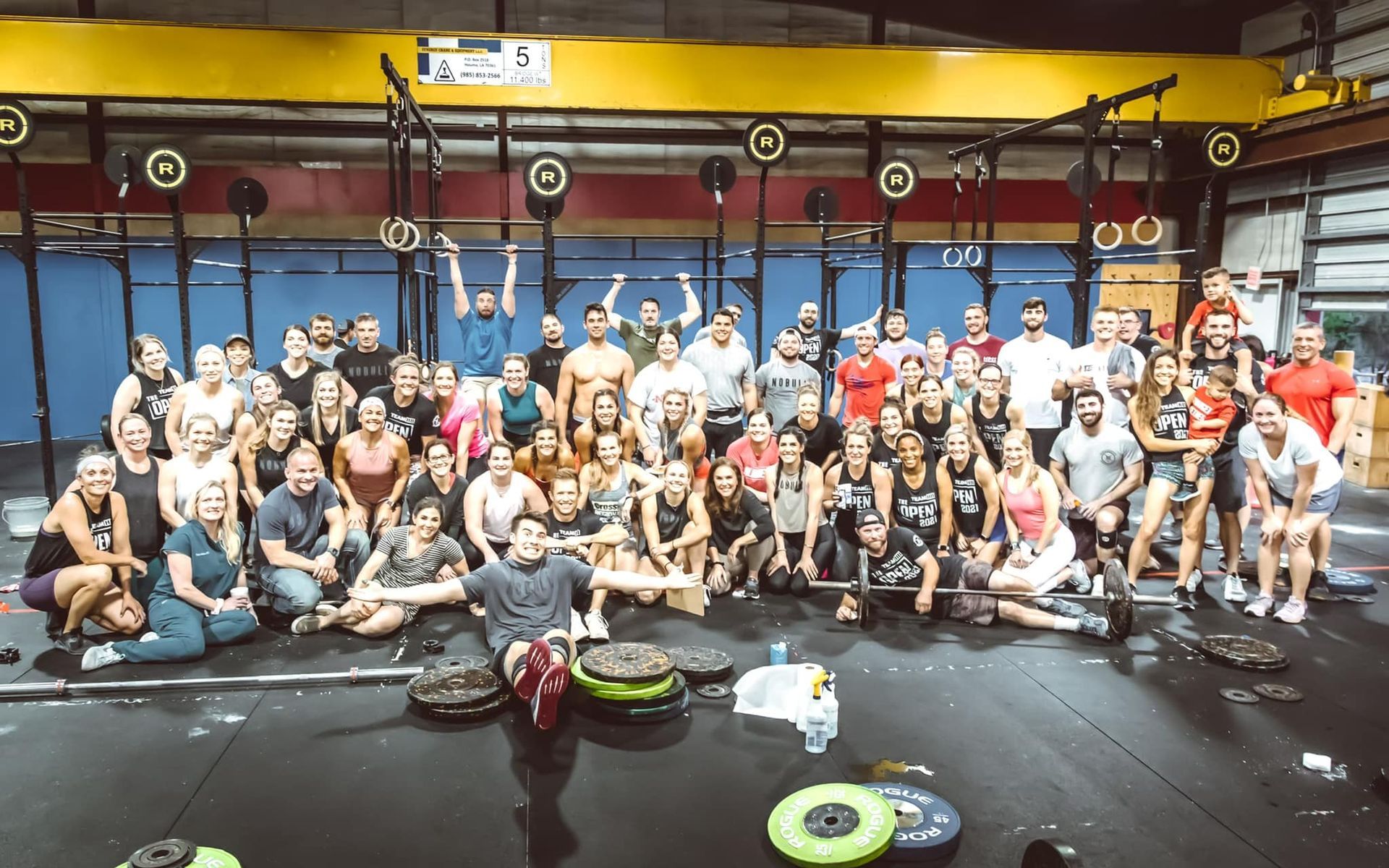 A large group of people are posing for a picture in a gym.