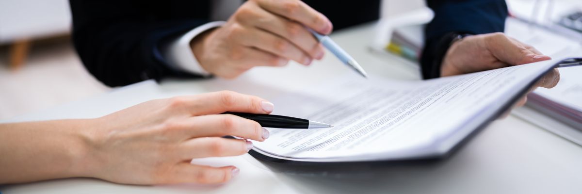 A person is holding a pen over a piece of paper.