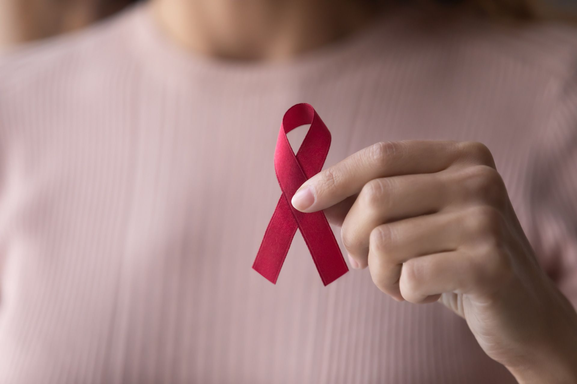 A woman is holding a red ribbon in her hand.