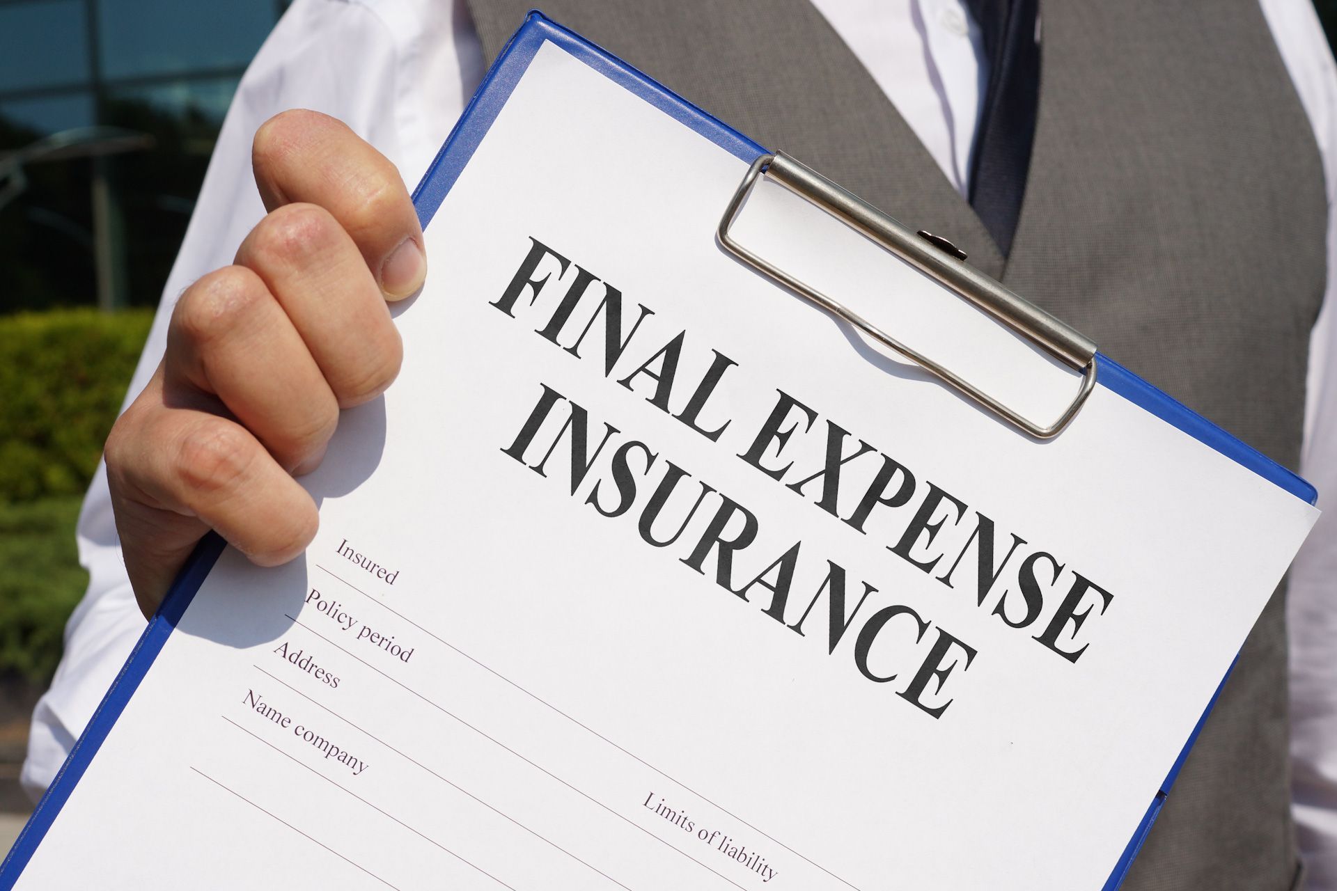 A man is holding a clipboard that says final expense insurance