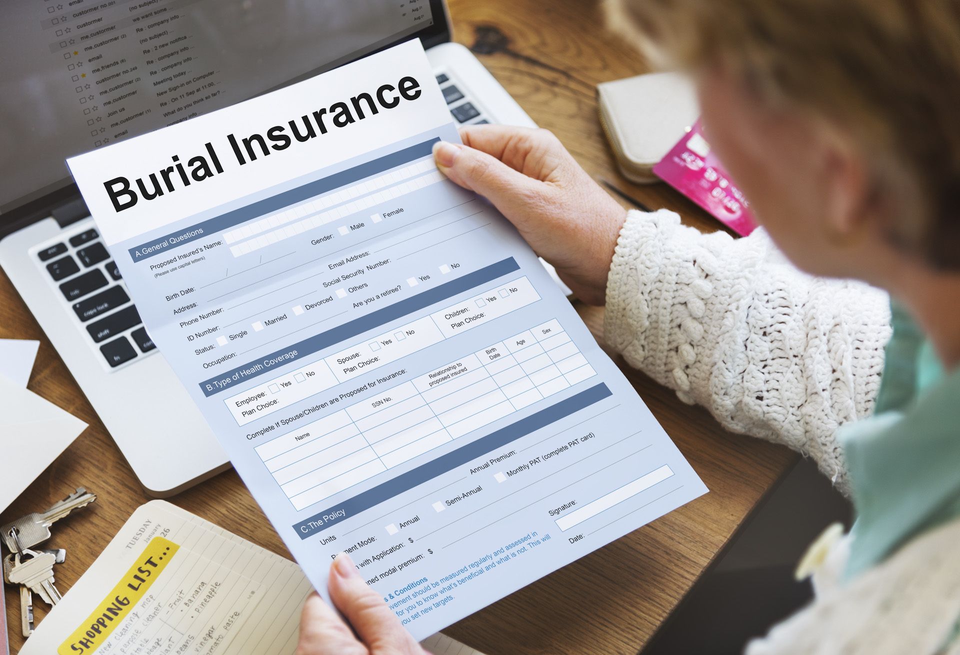 A woman is holding a piece of paper that says burial insurance.