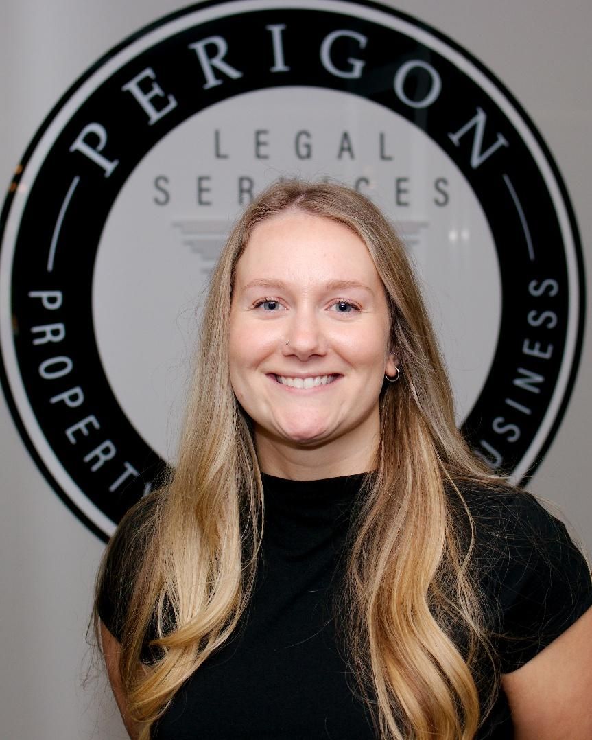 Portrait of a smiling woman in front of a Perrigon Legal Services logo