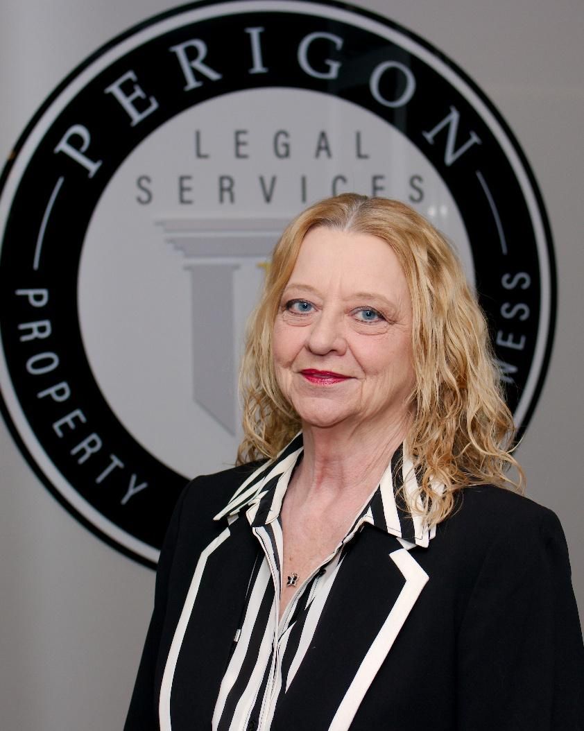 Woman in black blazer with white trim standing before a Perigoni Legal Services logo.