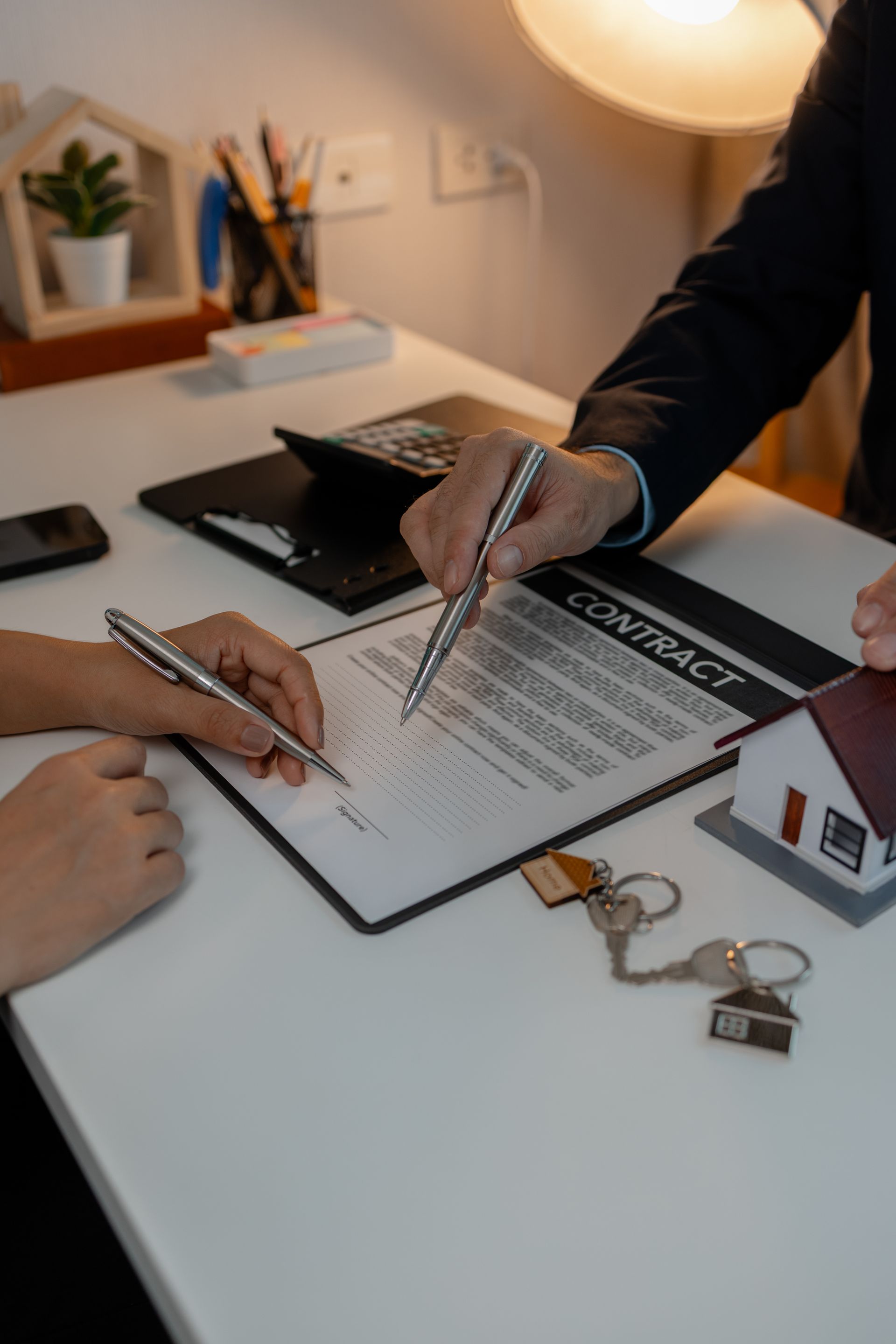 Older man with beard signing document, woman smiles beside him at a table.