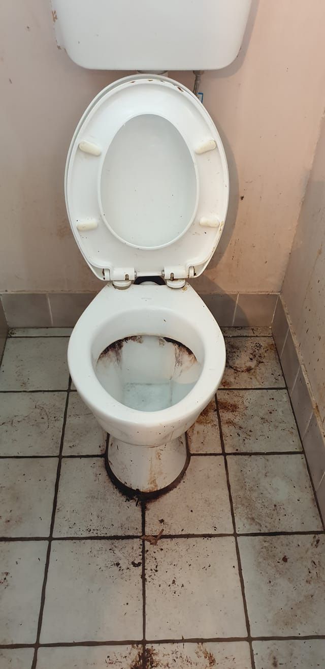 A Toilet With the Lid Up is Sitting on a Tiled Floor — Lease Clean Newcastle in Newcastle, NSW