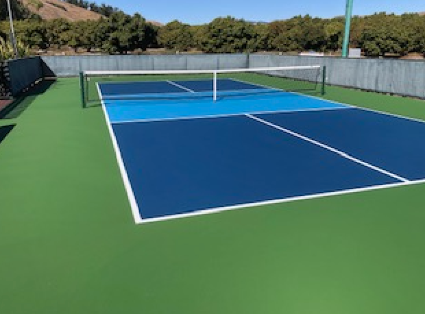 A blue and green tennis court with a white net
