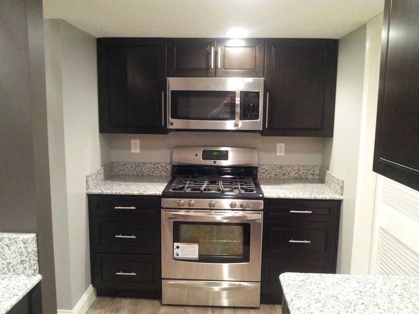 A kitchen with stainless steel appliances and black cabinets