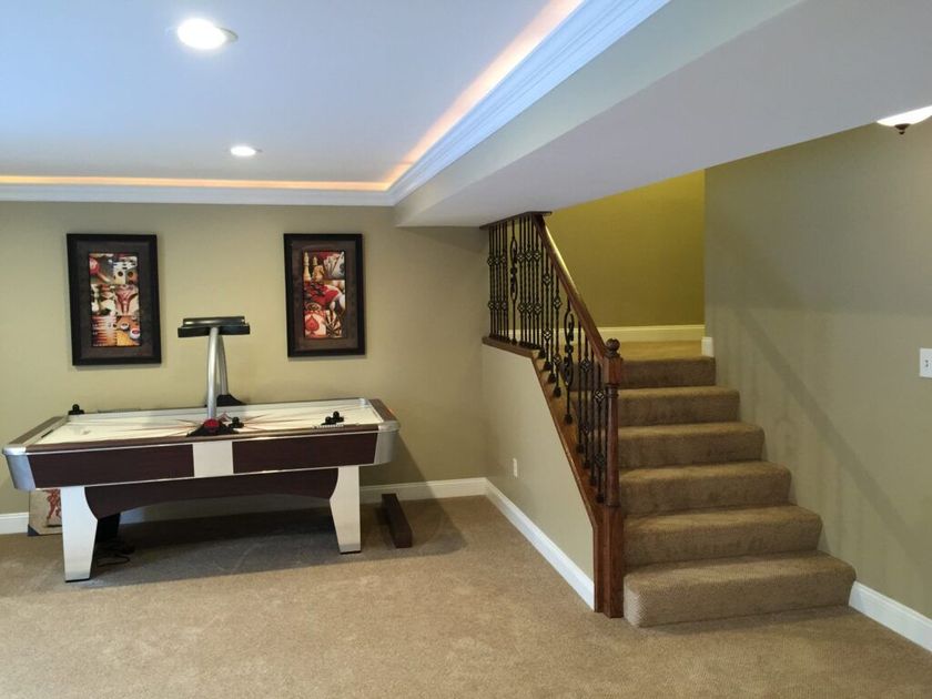 A basement with stairs and a pool table
