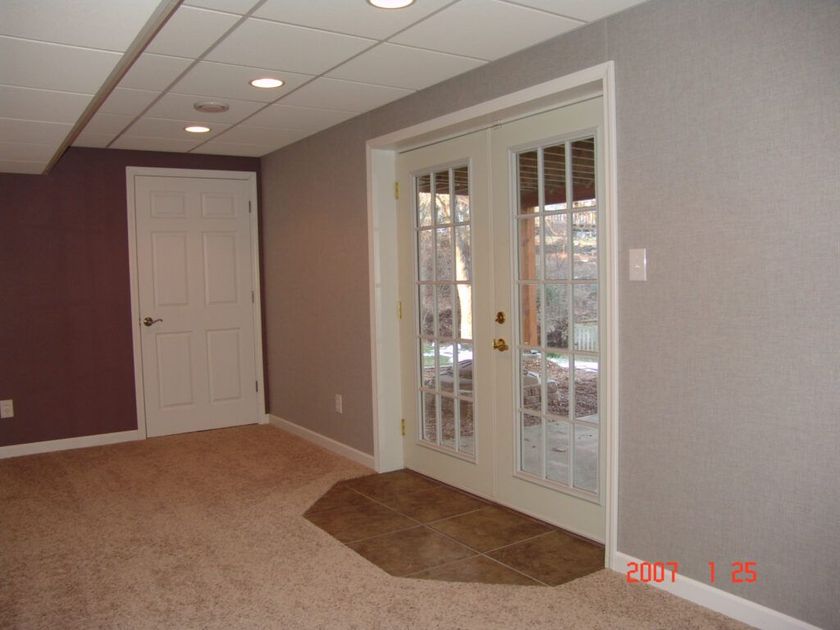 An empty room with french doors and a tile floor