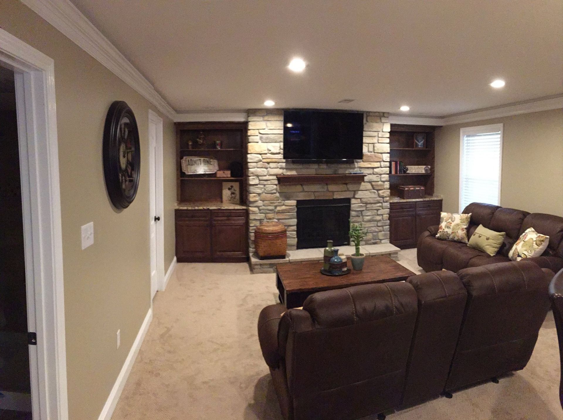 A living room with a couch , fireplace and television.