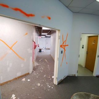 A hallway with graffiti on the wall that says x