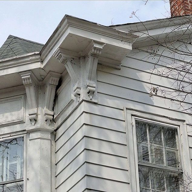 A white house with a roof and a few windows