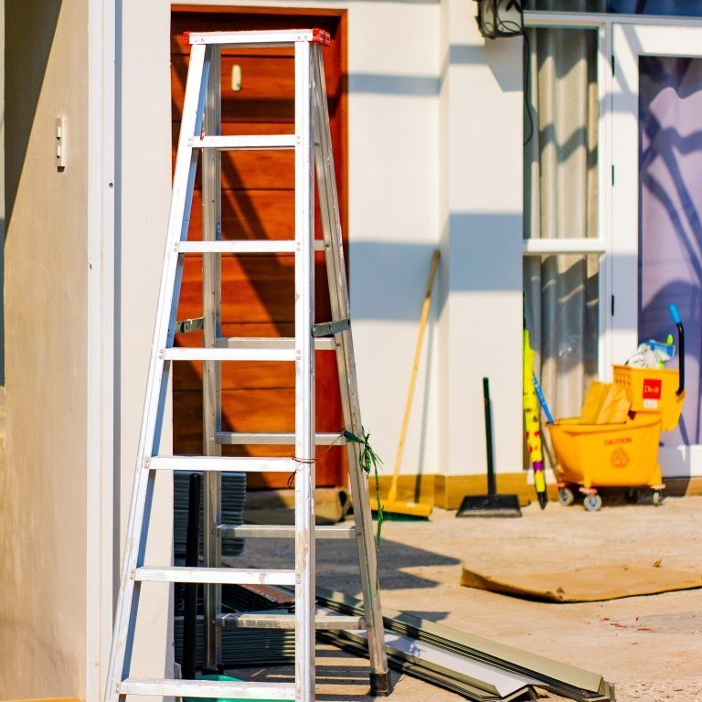 A ladder is sitting outside of a house under construction