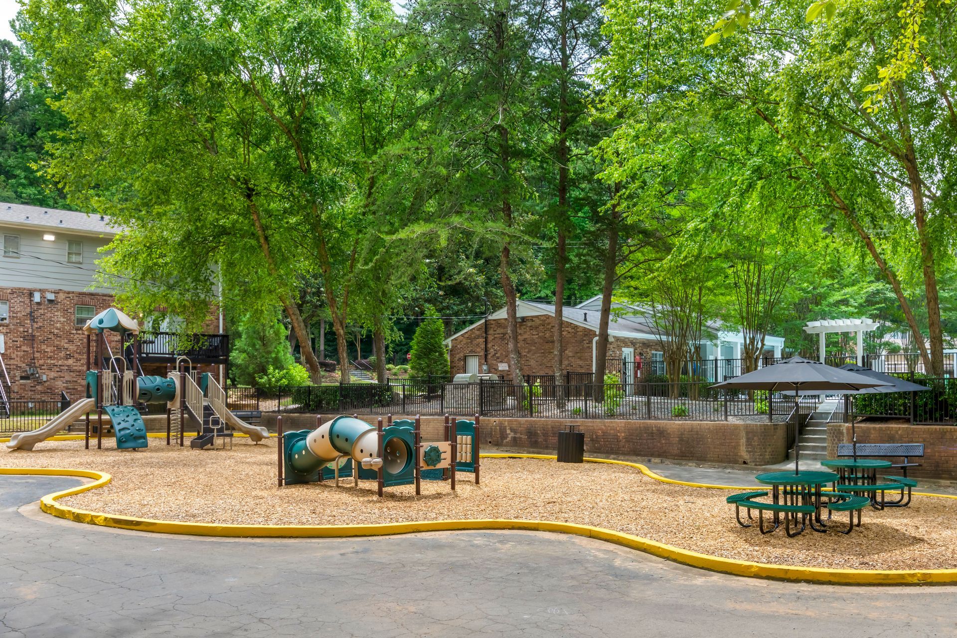 Brick building with white columns, door, and a brick walkway. Green lawn.