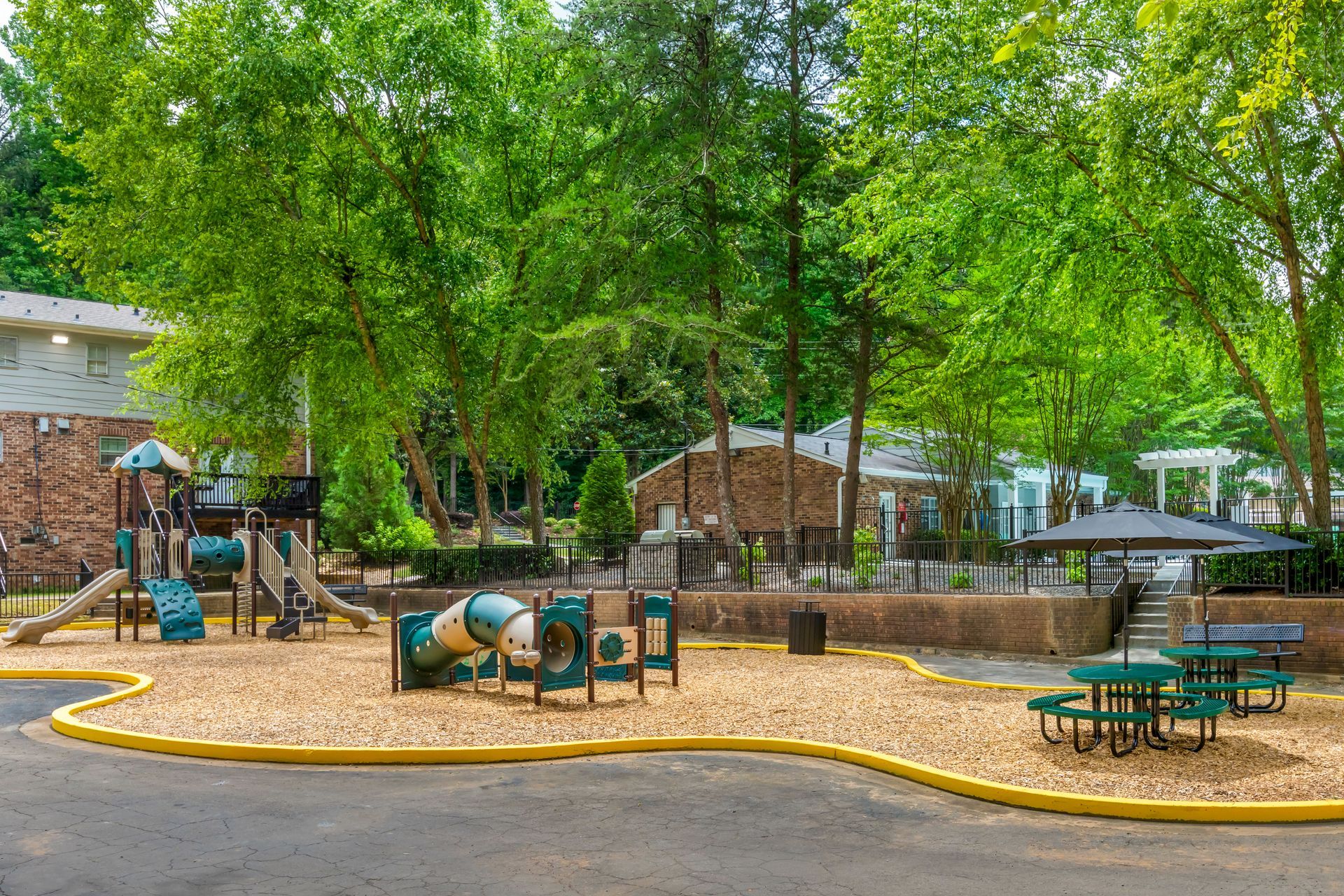 Brick building with white columns, door, and a brick walkway. Green lawn.