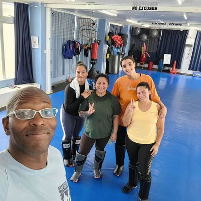 A group of people are posing for a picture in a gym.