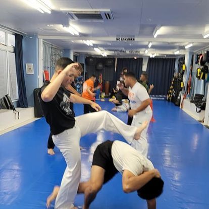 A group of men are practicing martial arts on a blue mat