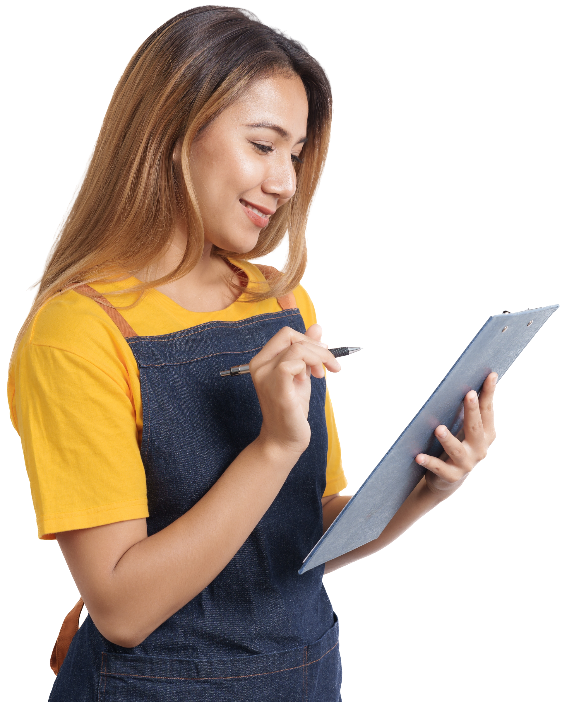 Woman in yellow shirt and denim apron writing on clipboard, smiling.