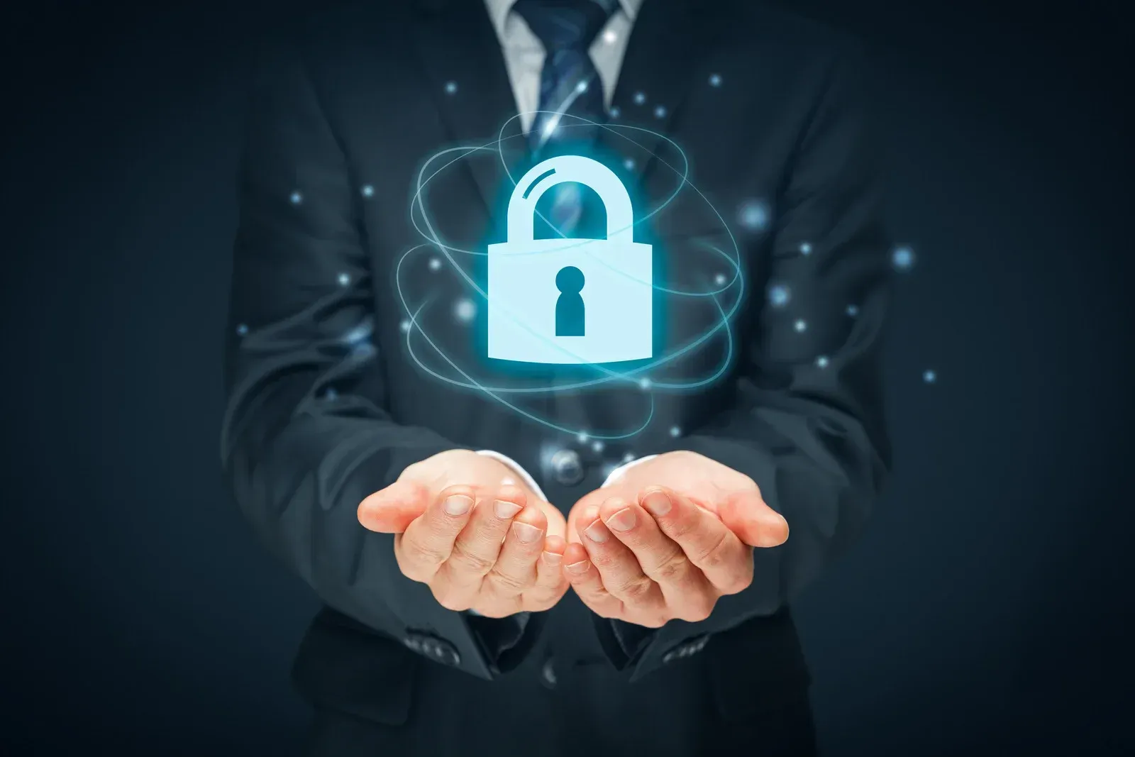 A man in a suit and tie is holding a padlock in his hands.